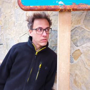 Andy Brunner vor einer Steinwand.